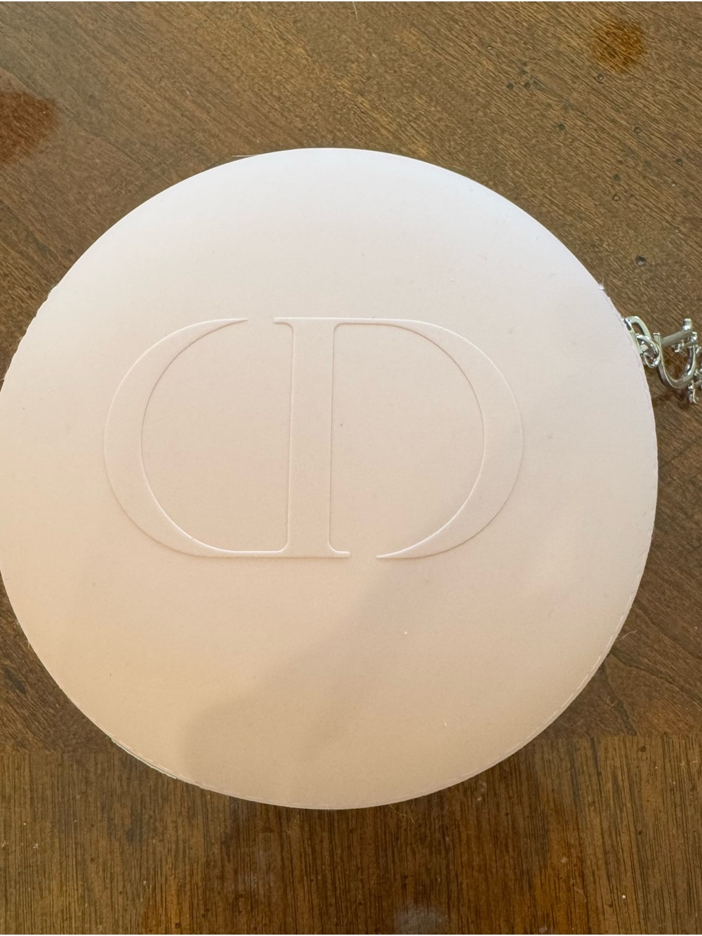 Dior Beauty Pale Pink Round makeup bag with silver Dior zipper logo.